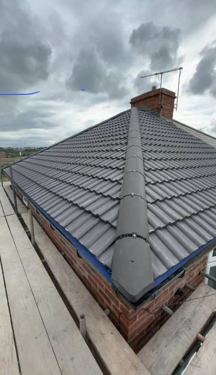 Dry ridge system fitted along the hip of a grey tiled roof