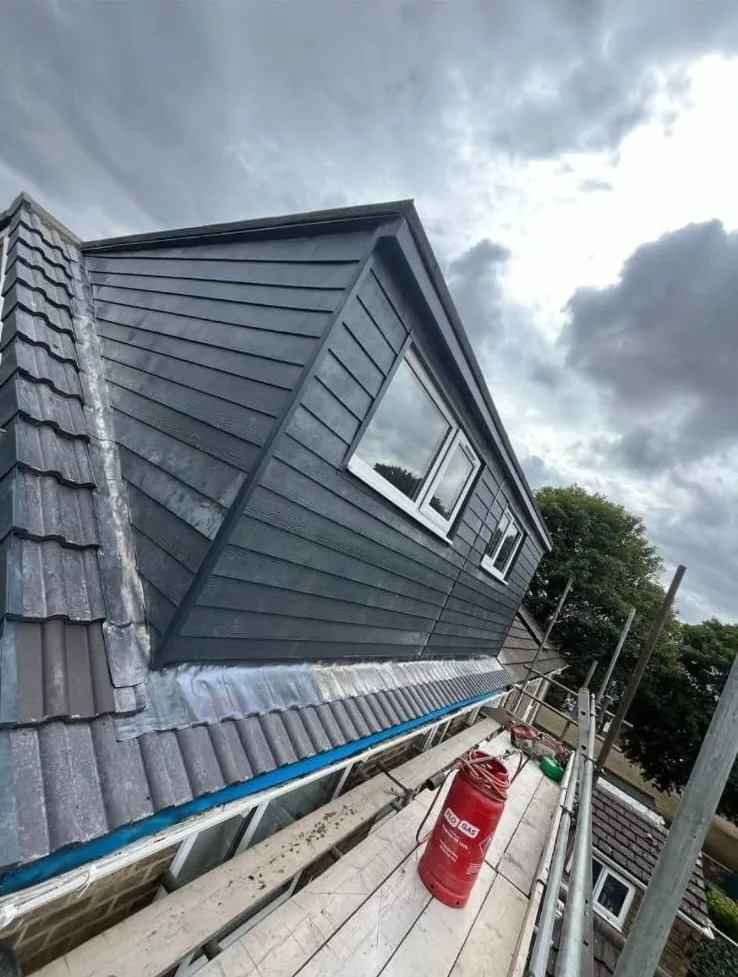 Dormer with dark cladding and new leadwork on a tiled roof