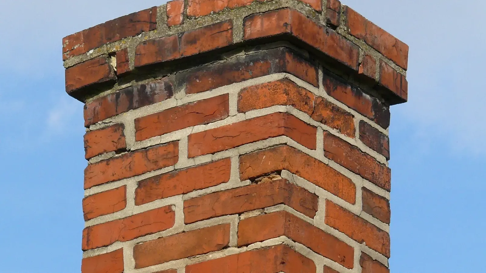 Chimney stack being repaired on a tiled roof