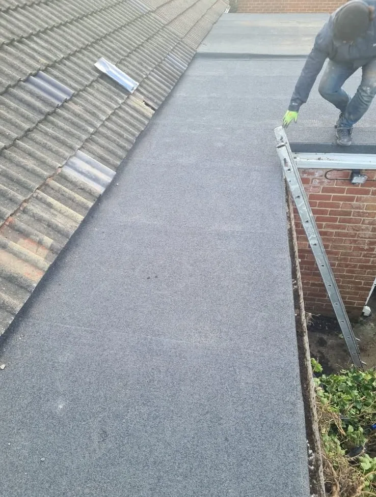 Mineral felt flat roof finished next to a tiled pitched roof