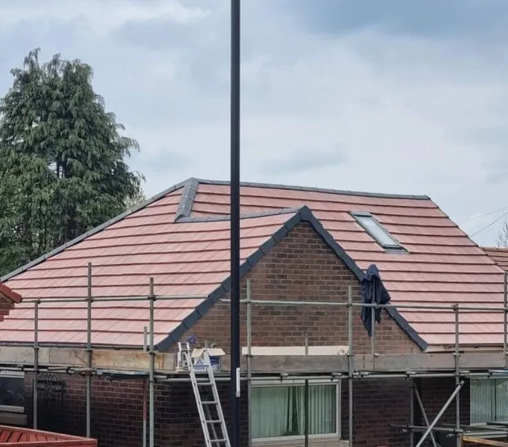 Full re-roof in red tiles on a detached house with scaffolding in place