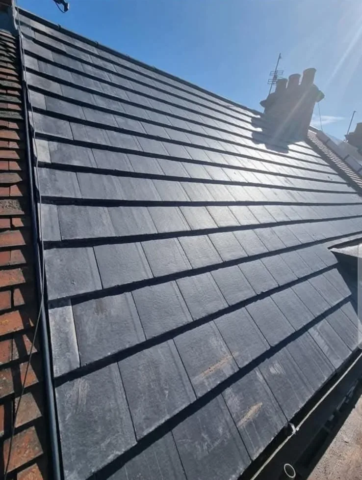 Close-up of a new re-roof in dark flat interlocking tiles